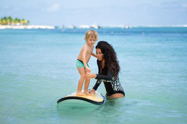 Maman apprenant à son fils à tenir sur une planche de surf